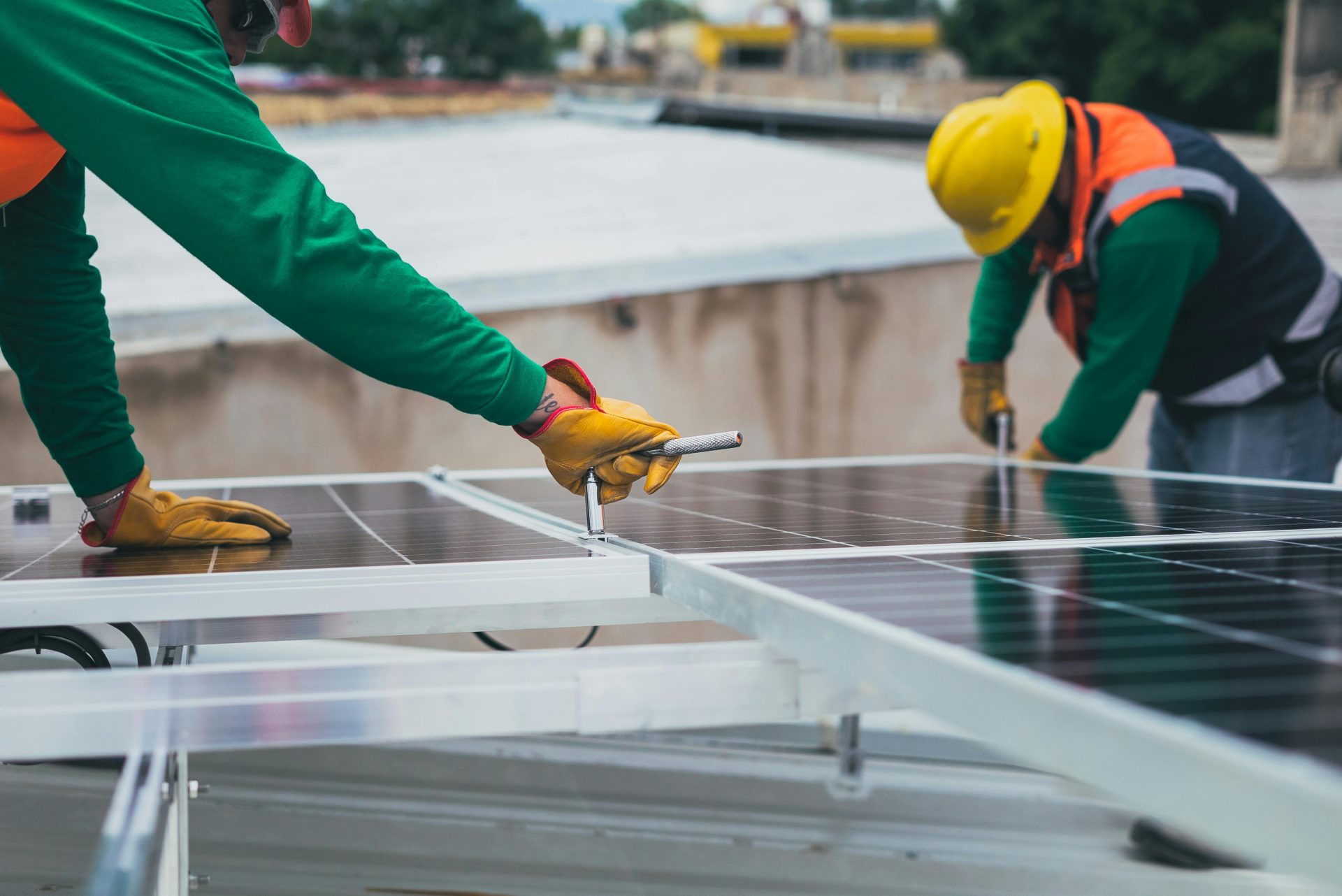 Unos trabajadores instalan paneles solares en un tejado, impulsando así las energías renovables.